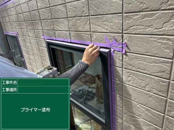 窓枠にプライマーを塗る作業中