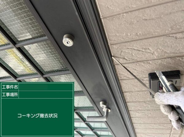 玄関まわりの外壁とサッシの間から、古くなったコーキング材をカッターで丁寧に取り除いている様子