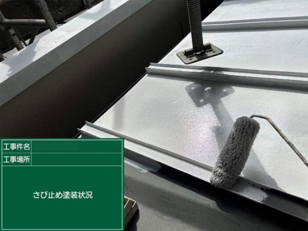 ローラーで金属屋根にさび止めを塗装している様子