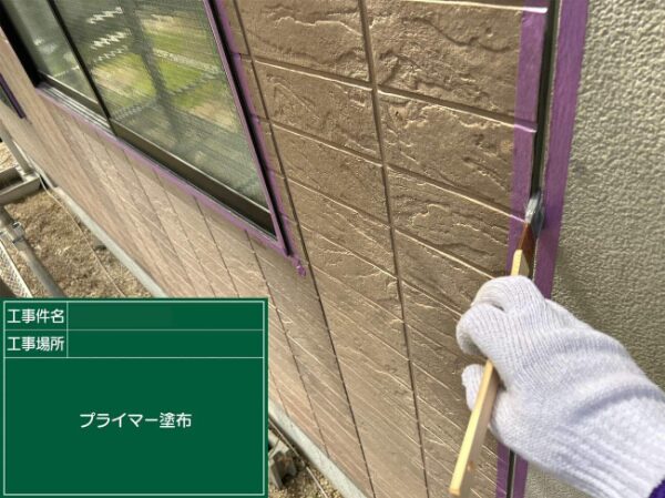 サッシ横の外壁目地にプライマーを塗っている様子
