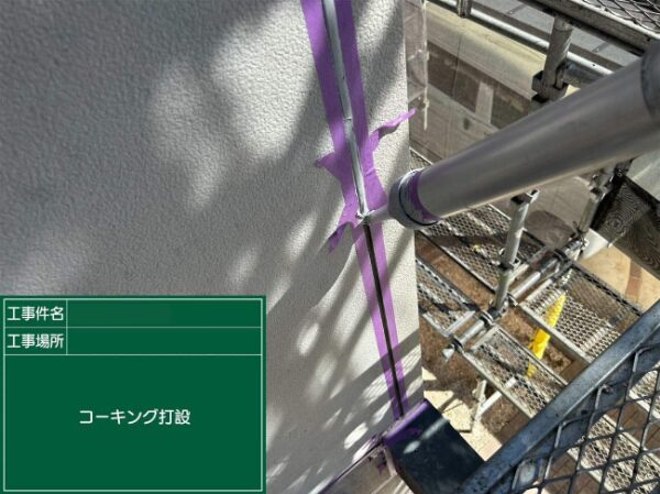外壁の縦目地にコーキング材をガンで充填している様子