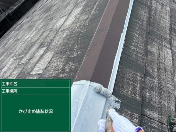 屋根上の棟板金にさび止めを塗っているところ