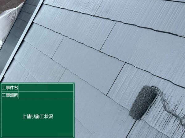 屋根の端部を丁寧に上塗りしている作業中の様子